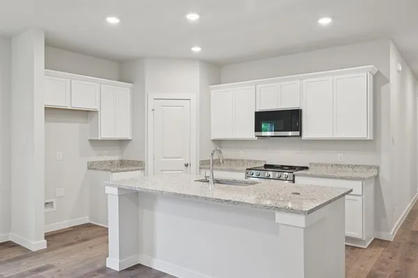 a kitchen with stainless steel appliances granite countertop a sink a stove a microwave a sink and cabinets