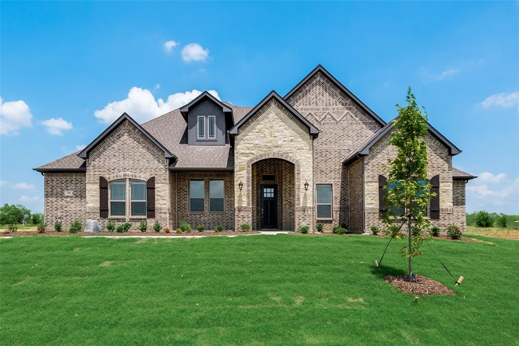 a front view of a house with a garden and yard