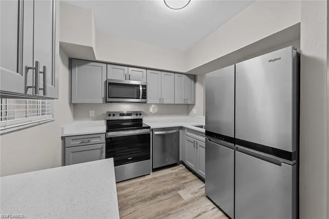a kitchen with stainless steel appliances and refrigerator