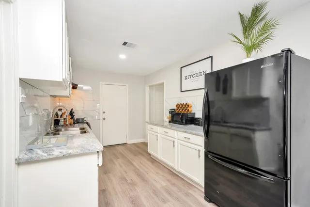 a kitchen with granite countertop a refrigerator and a sink