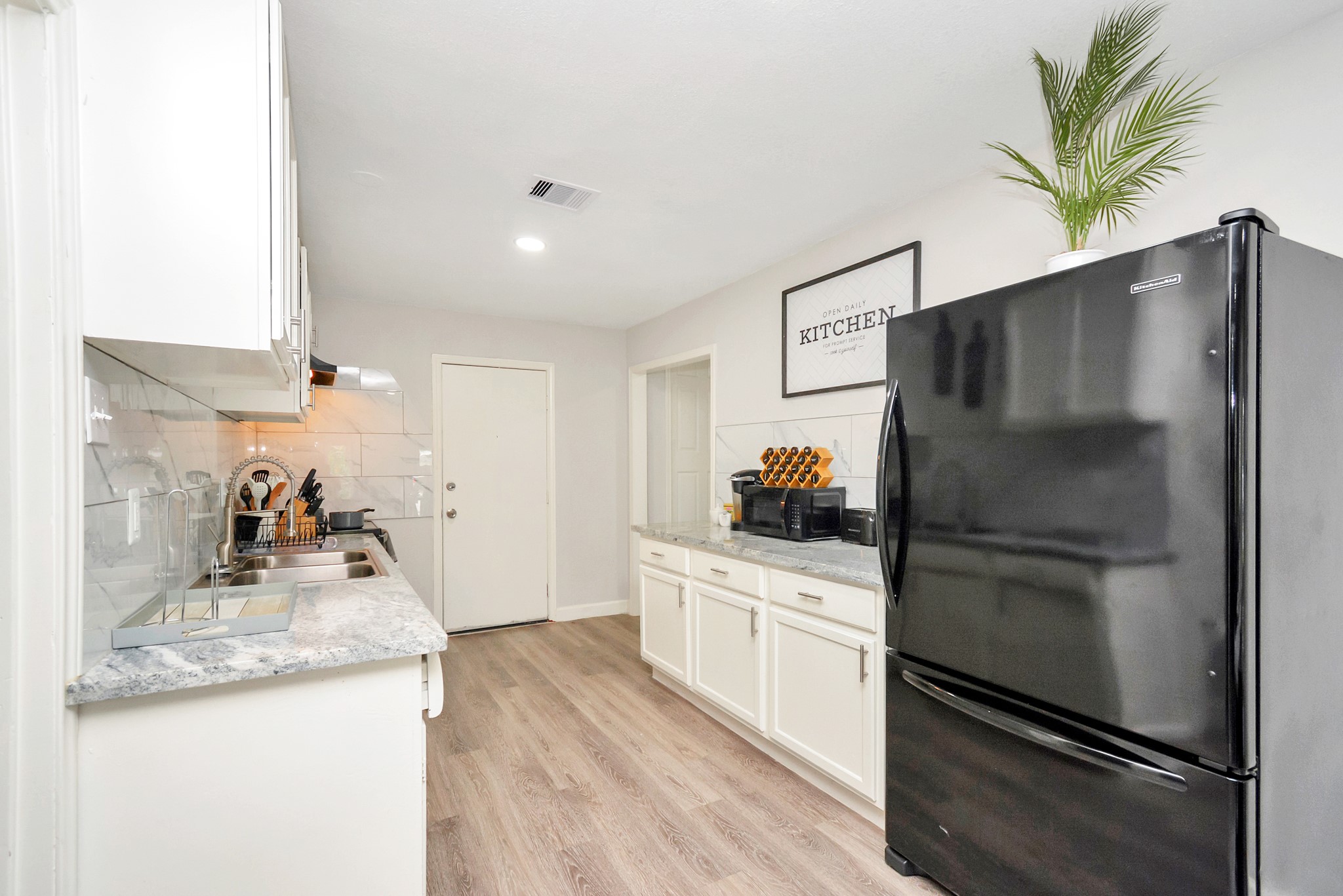 4710 Paradise Lane Houston, TX 77048 - Photo 15 of 42 a kitchen with granite countertop a refrigerator and a sink