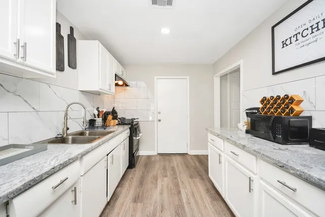 a kitchen with stainless steel appliances granite countertop a sink stove and cabinets