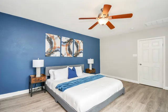 a bedroom with a bed and a painting on the wall