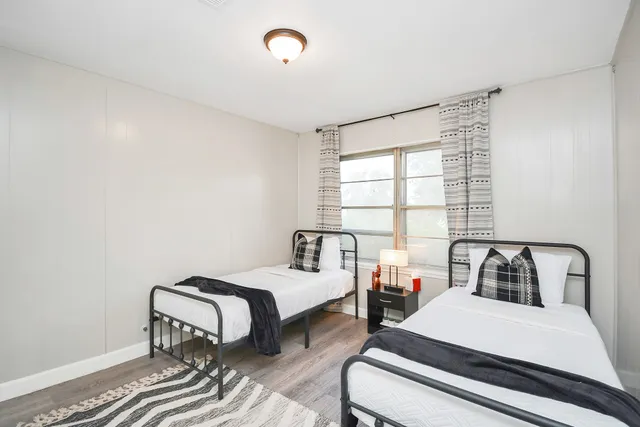 a bedroom with two beds and a large window