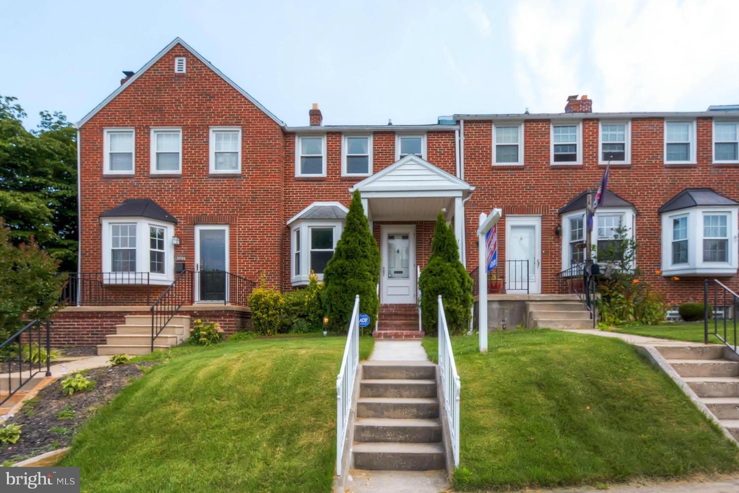 a front view of a house with yard and green space