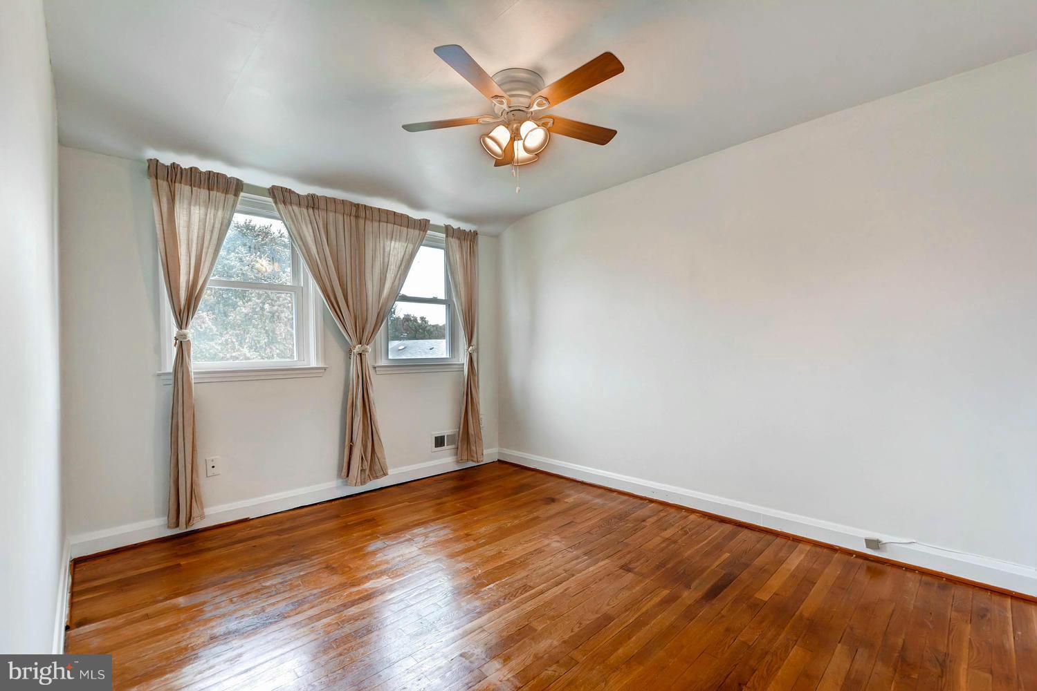 8325 Byington Road Baltimore, MD 21286 - Photo 19 of 28 an empty room with wooden floor and windows