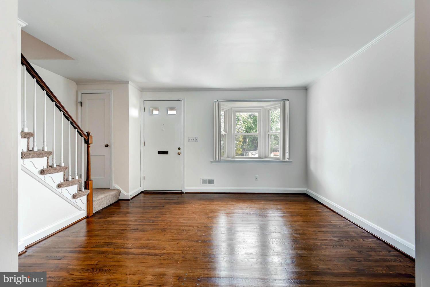 8325 Byington Road Baltimore, MD 21286 - Photo 6 of 28 a view of an empty room with wooden floor and a window