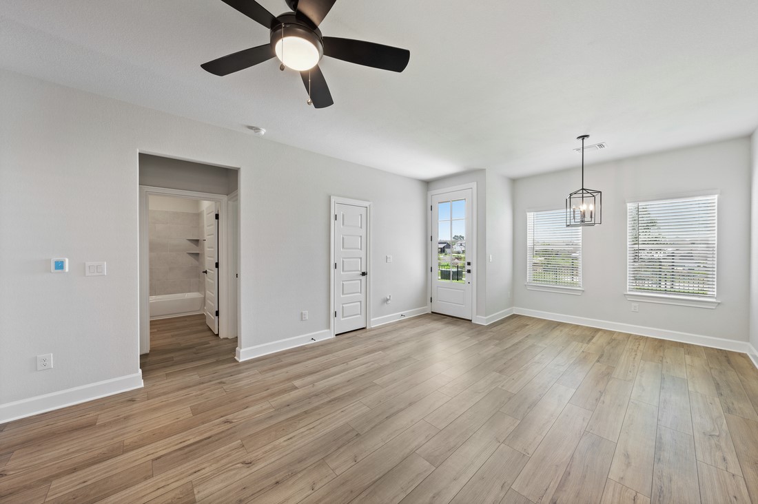 9316 Gladsome Path Manor, TX 78653 - Photo 3 of 18 a view of an empty room with wooden floor and a window