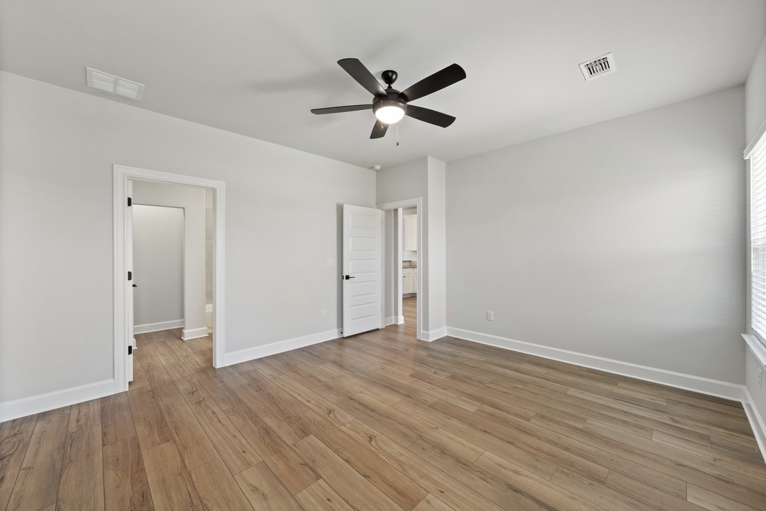 9316 Gladsome Path Manor, TX 78653 - Photo 10 of 18 an empty room with wooden floor and a ceiling fan