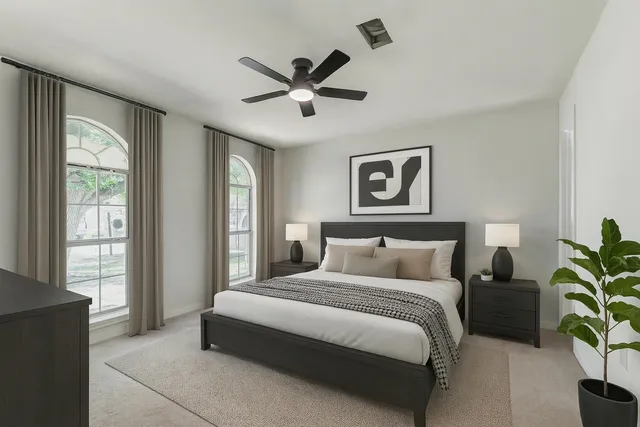 a bedroom with a large bed and a potted plant