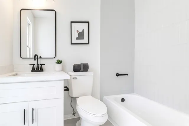 a bathroom with a sink a toilet and shower