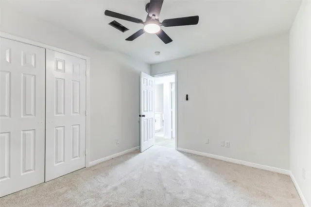an empty room with chandelier fan