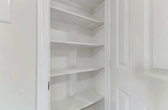 a view of walk in closet with empty racks