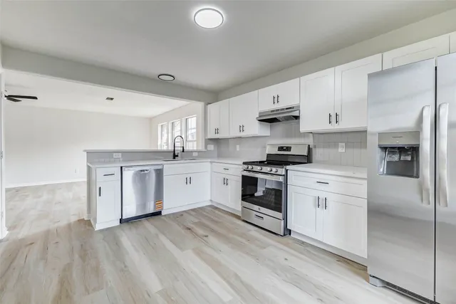 a kitchen with granite countertop white cabinets and white appliances