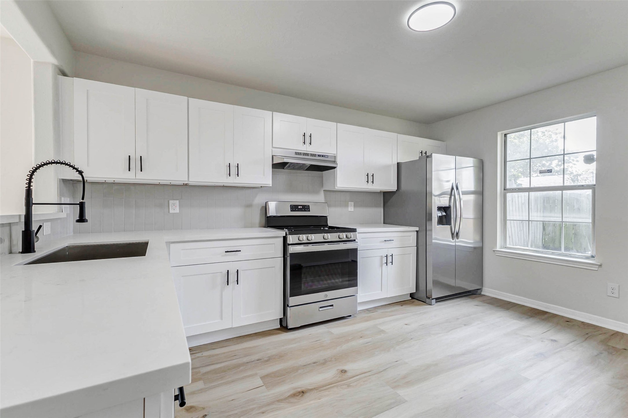 10102 Wiggins Street Houston, TX 77029 - Photo 5 of 26 a kitchen with stainless steel appliances white cabinets a sink a stove a refrigerator and white cabinets