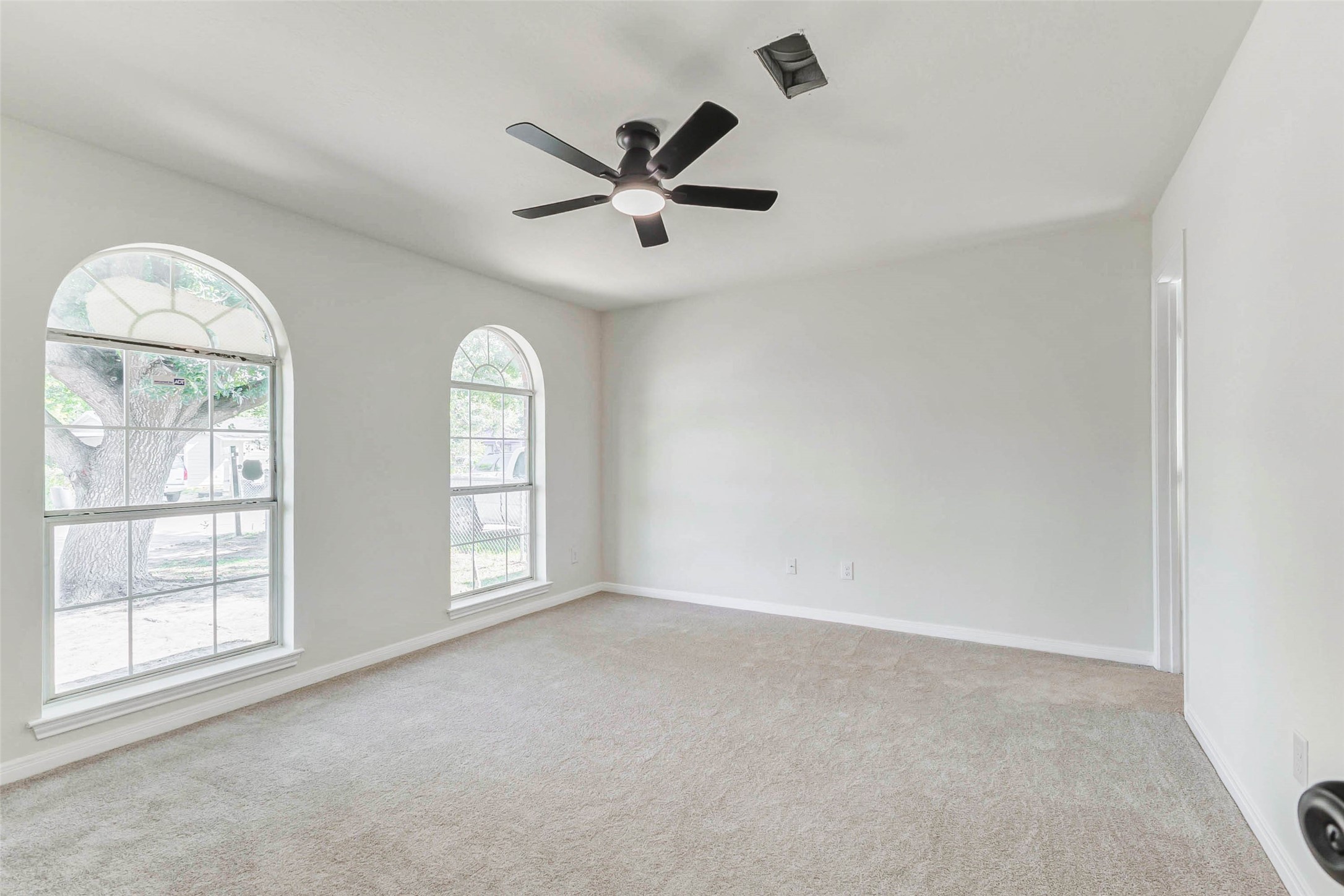 10102 Wiggins Street Houston, TX 77029 - Photo 10 of 26 an empty room with windows and ceiling fan