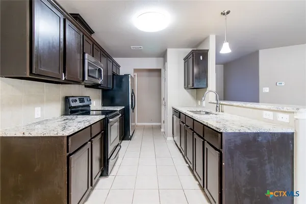a kitchen with granite countertop cabinets and steel stainless steel appliances