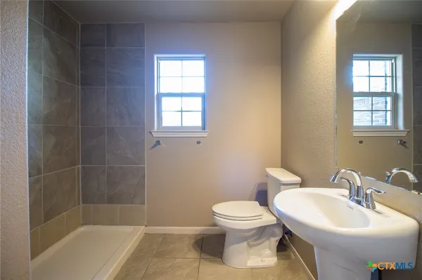 a bathroom with a sink toilet and shower