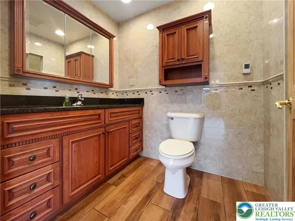 a bathroom with a toilet a sink and mirror