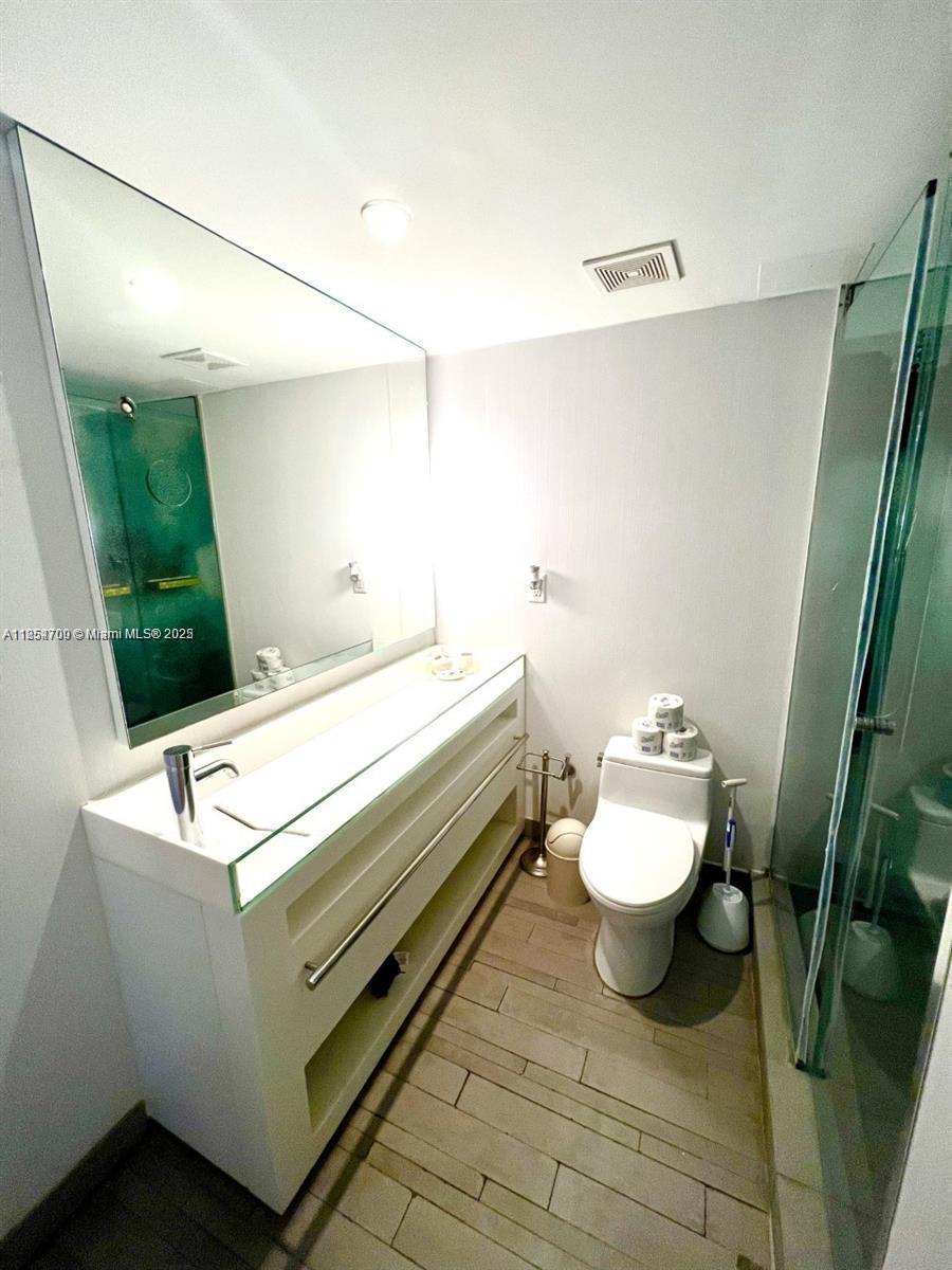 1100 West Avenue, Unit 425 Miami Beach, FL 33139 - Photo 11 of 17 a bathroom with a sink a toilet and a mirror