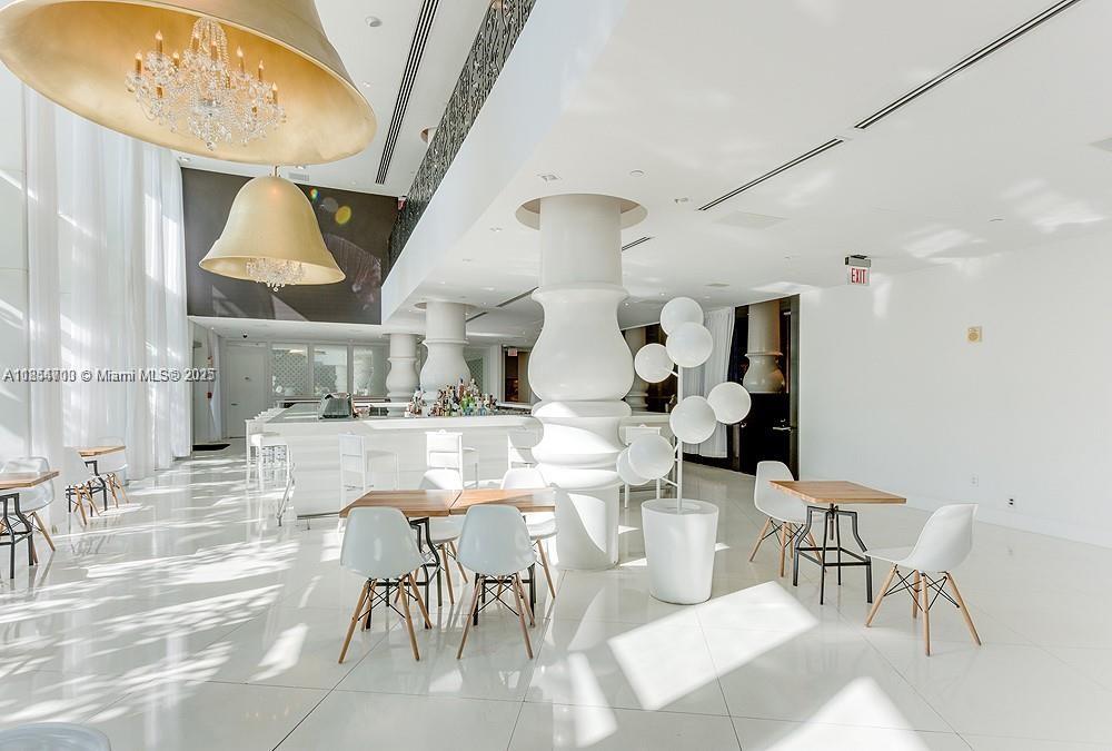 1100 West Avenue, Unit 425 Miami Beach, FL 33139 - Photo 3 of 17 a living room with lots of furniture and a chandelier