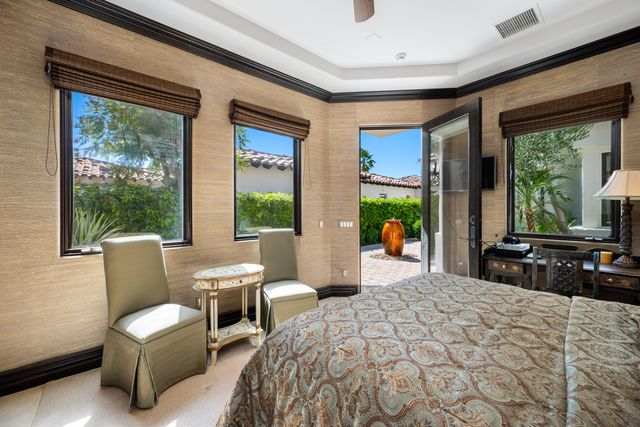 a bedroom with a bed and large windows