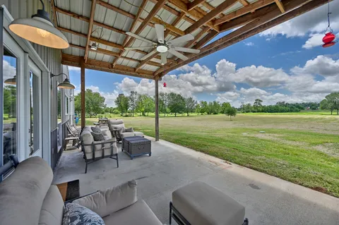 a view of a patio with a table chairs and a backyard