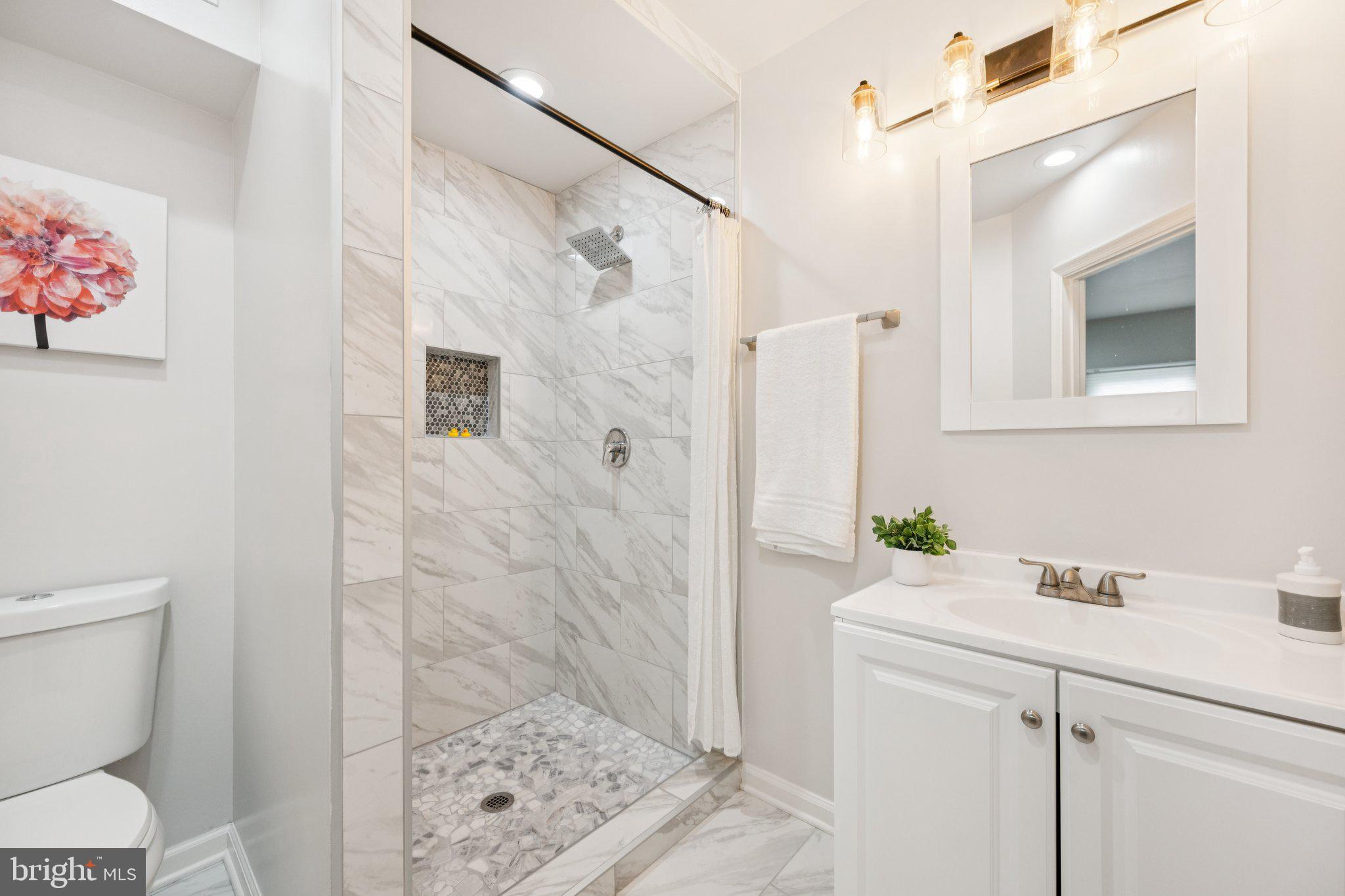 4014 37th Street Mount Rainier, MD 20712 - Photo 14 of 26 a bathroom with a granite countertop sink a toilet and shower