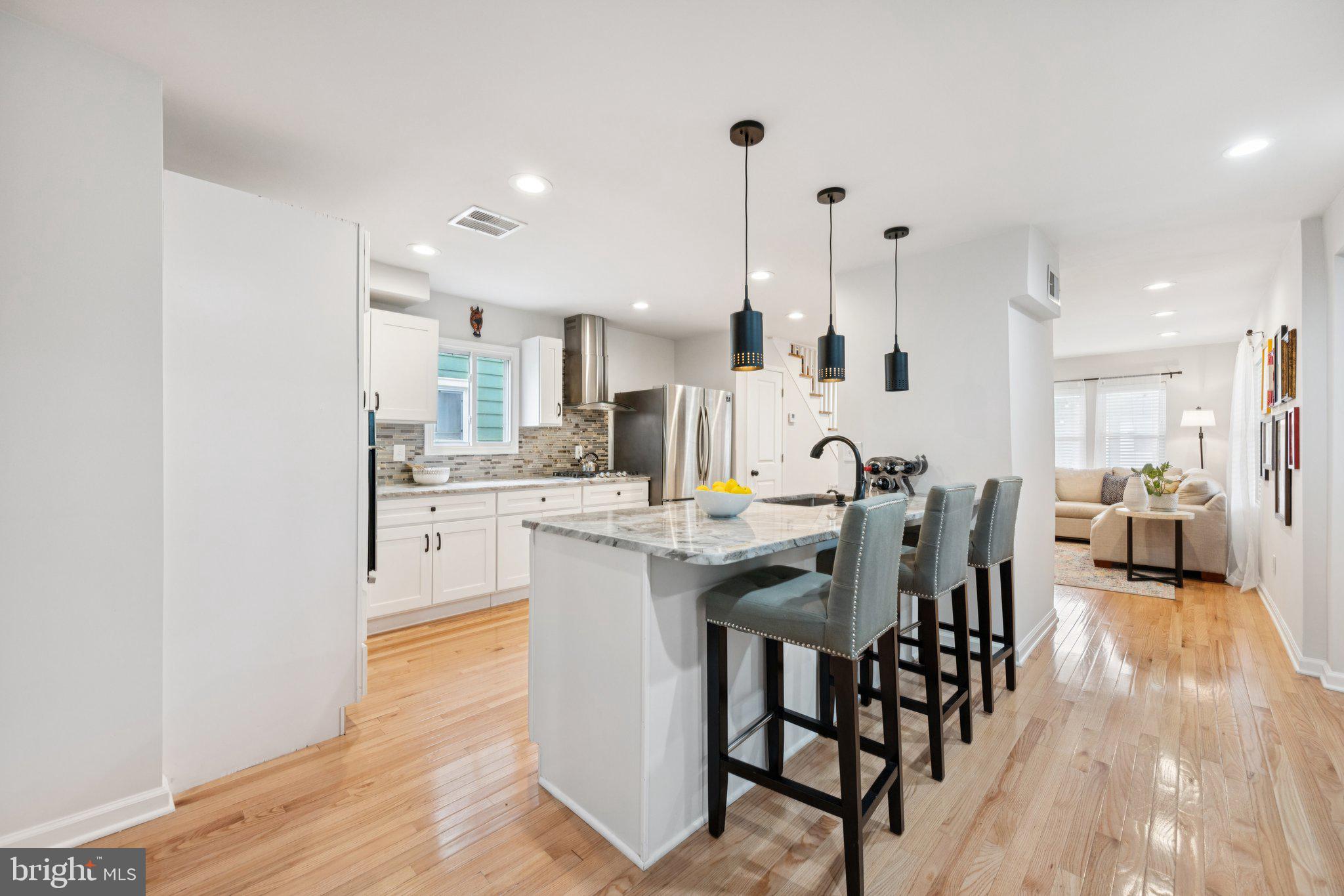 4014 37th Street Mount Rainier, MD 20712 - Photo 5 of 26 a dining hall with stainless steel appliances kitchen island granite countertop a dining table chairs and view kitchen