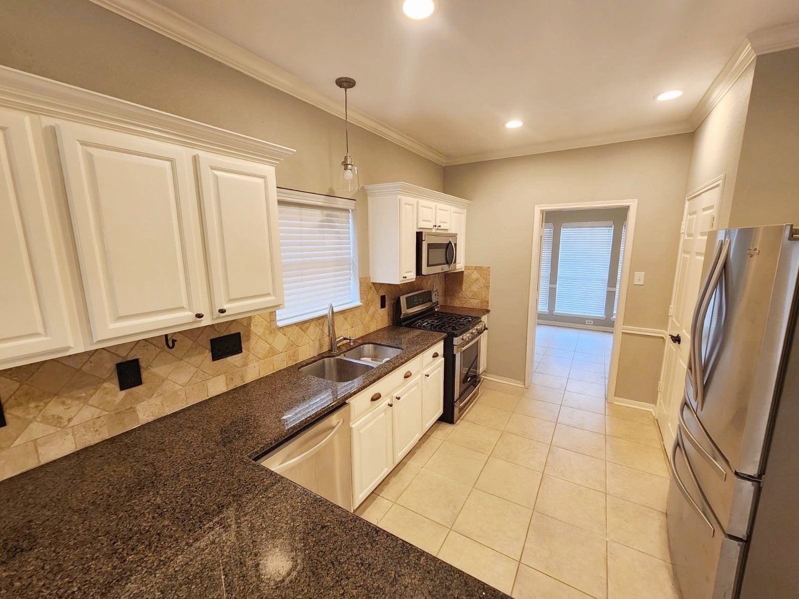 16302 Flint Run Way Sugar Land, TX 77498 - Photo 11 of 27 a large white kitchen with stainless steel appliances granite countertop a stove a sink a refrigerator a microwave and cabinets