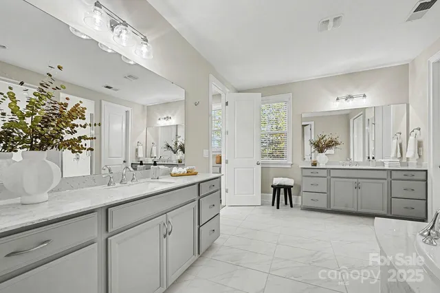 a large bathroom with a double vanity sink a mirror a bathtub and with shower