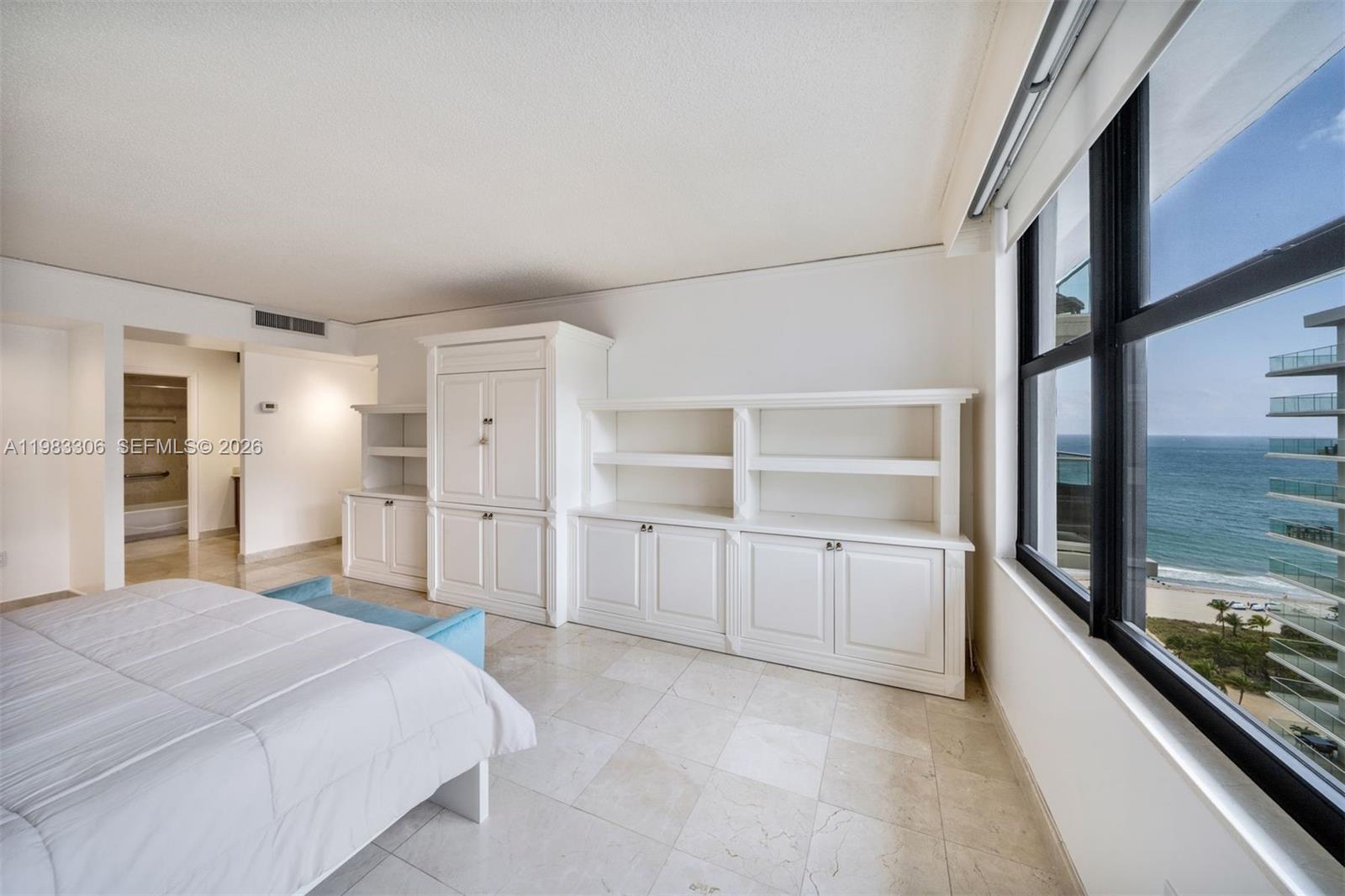 9801 Collins Avenue, Unit 19H Bal Harbour, FL 33154 - Photo 12 of 28 a room with a bed and a large window