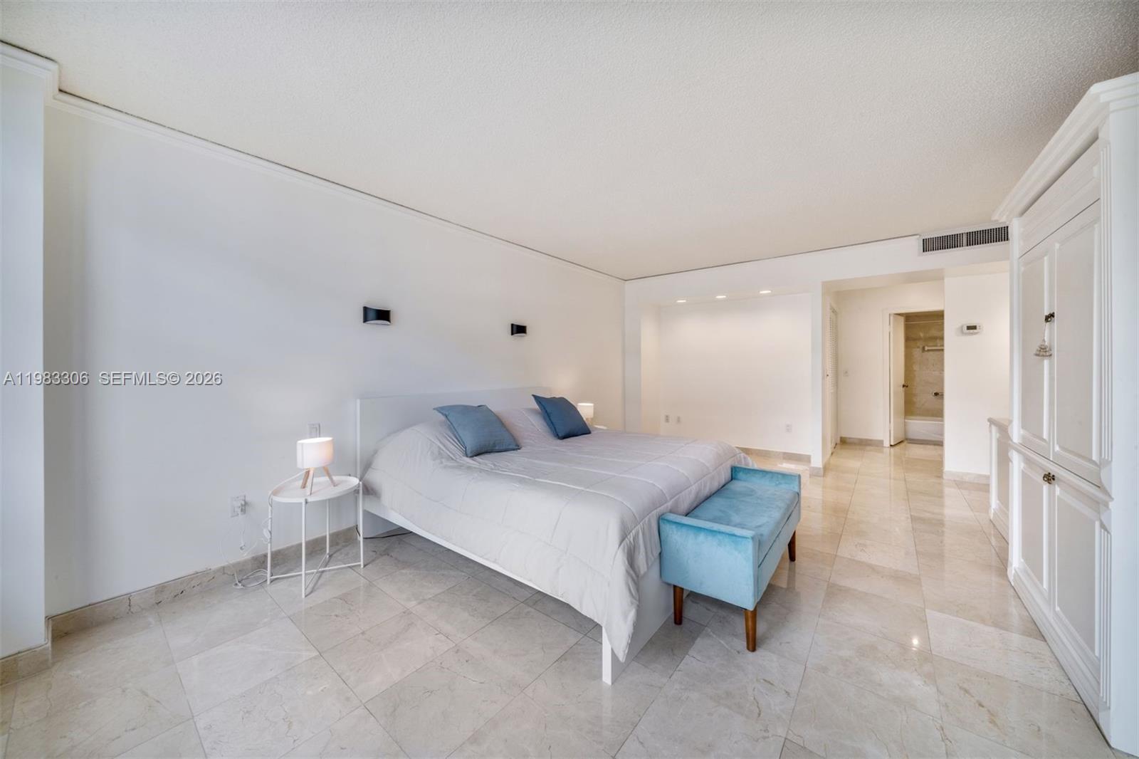 9801 Collins Avenue, Unit 19H Bal Harbour, FL 33154 - Photo 13 of 28 a bedroom with a bed and a table