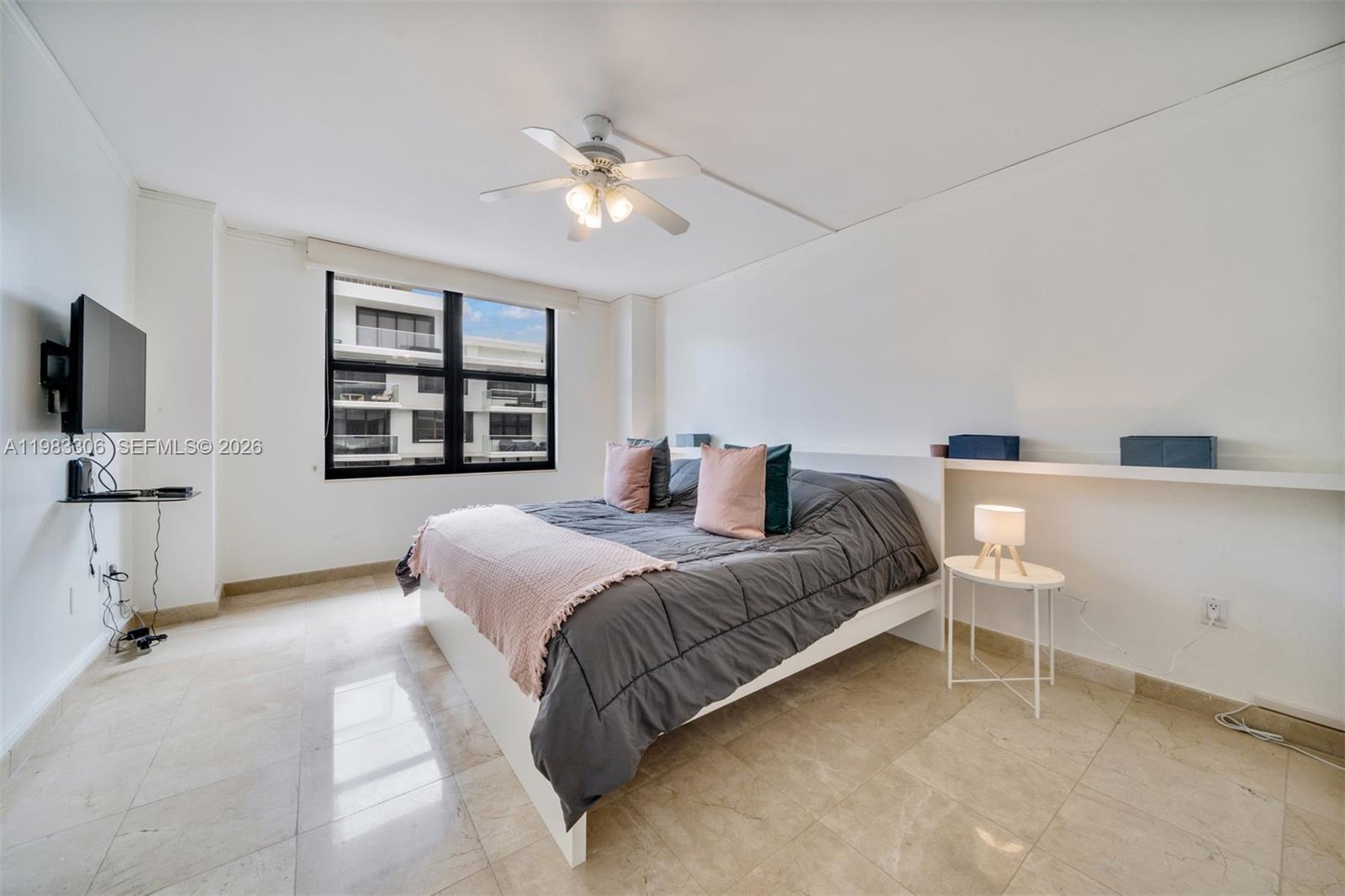 9801 Collins Avenue, Unit 19H Bal Harbour, FL 33154 - Photo 14 of 28 a spacious bedroom with a bed and a flat screen tv