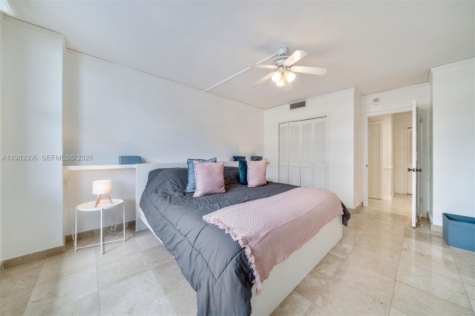9801 Collins Avenue, Unit 19H Bal Harbour, FL 33154 - Photo 15 of 28 a bedroom with a bed and a chandelier