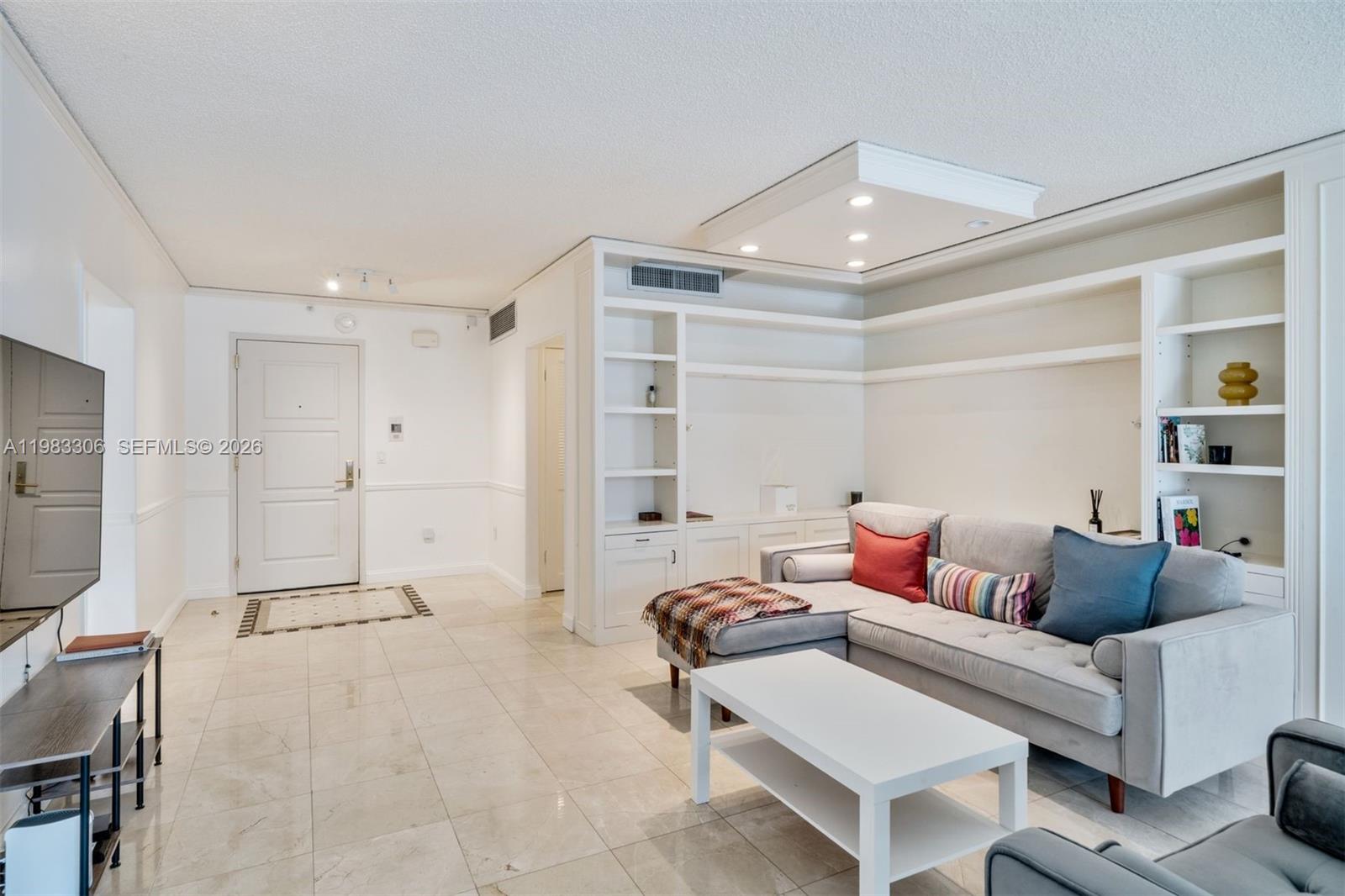 9801 Collins Avenue, Unit 19H Bal Harbour, FL 33154 - Photo 5 of 28 a living room with furniture and a flat screen tv