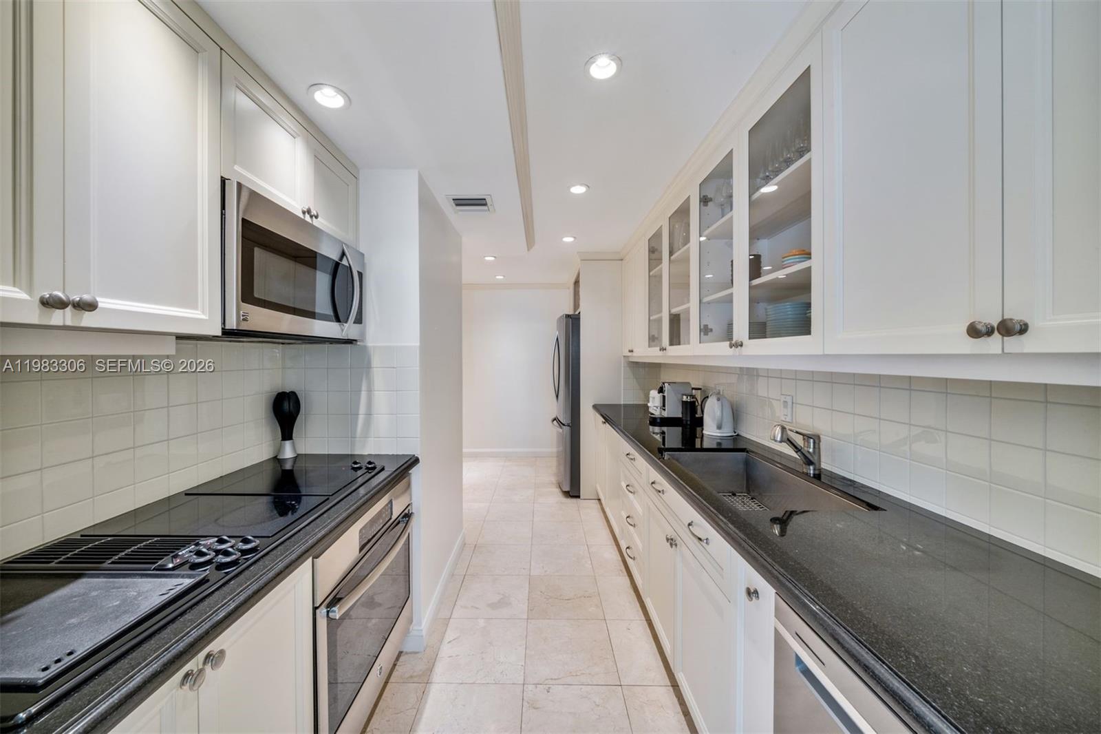 9801 Collins Avenue, Unit 19H Bal Harbour, FL 33154 - Photo 7 of 28 a kitchen with granite countertop a stove and a sink