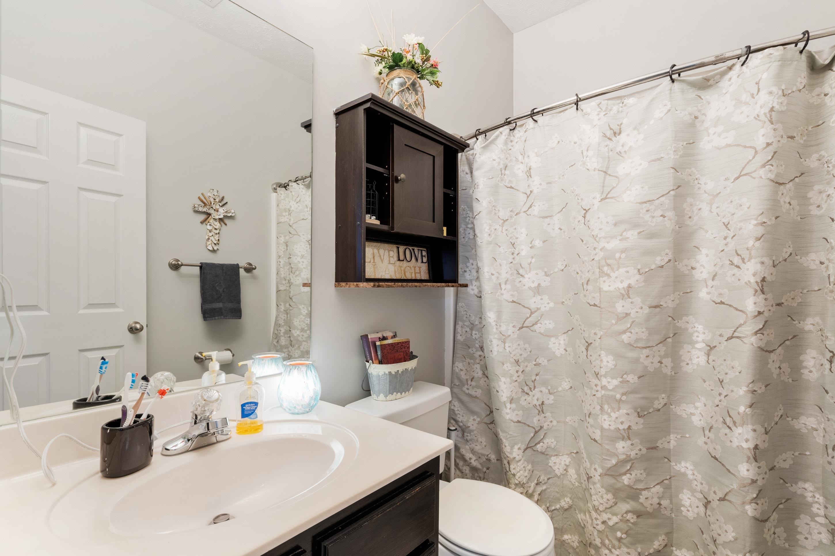 7757 Brunswick Road Millington, TN 38053 - Photo 16 of 40 Bathroom featuring a single vanity with an integrated sink, a rectangular mirror, and a wall-mounted towel bar