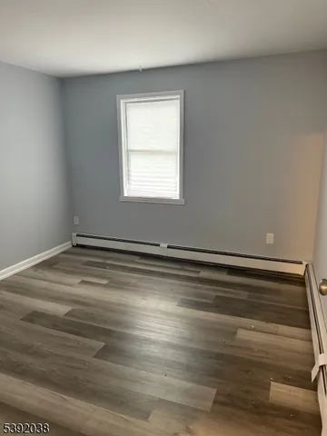 a view of a room with wooden floor and window