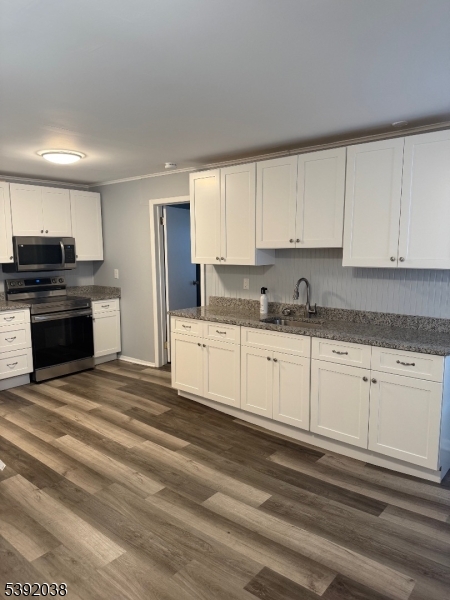 174 Main Street, Unit 2L Franklin, NJ 07416 - Photo 5 of 12 a kitchen with granite countertop white cabinets and stainless steel appliances