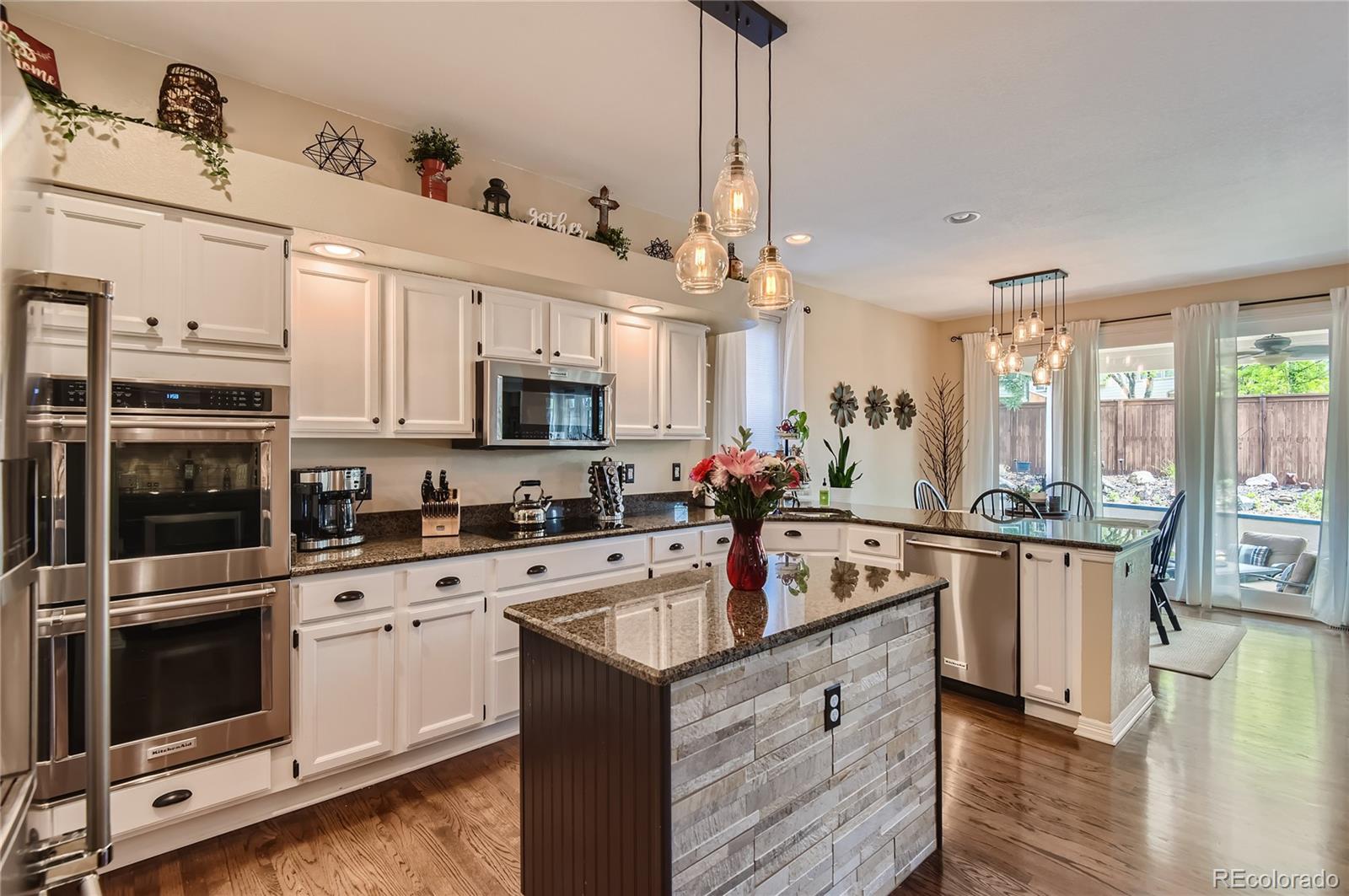 9212 Princeton Street Highlands Ranch, CO 80130 - Photo 11 of 40 a kitchen with stainless steel appliances granite countertop a sink stove and refrigerator