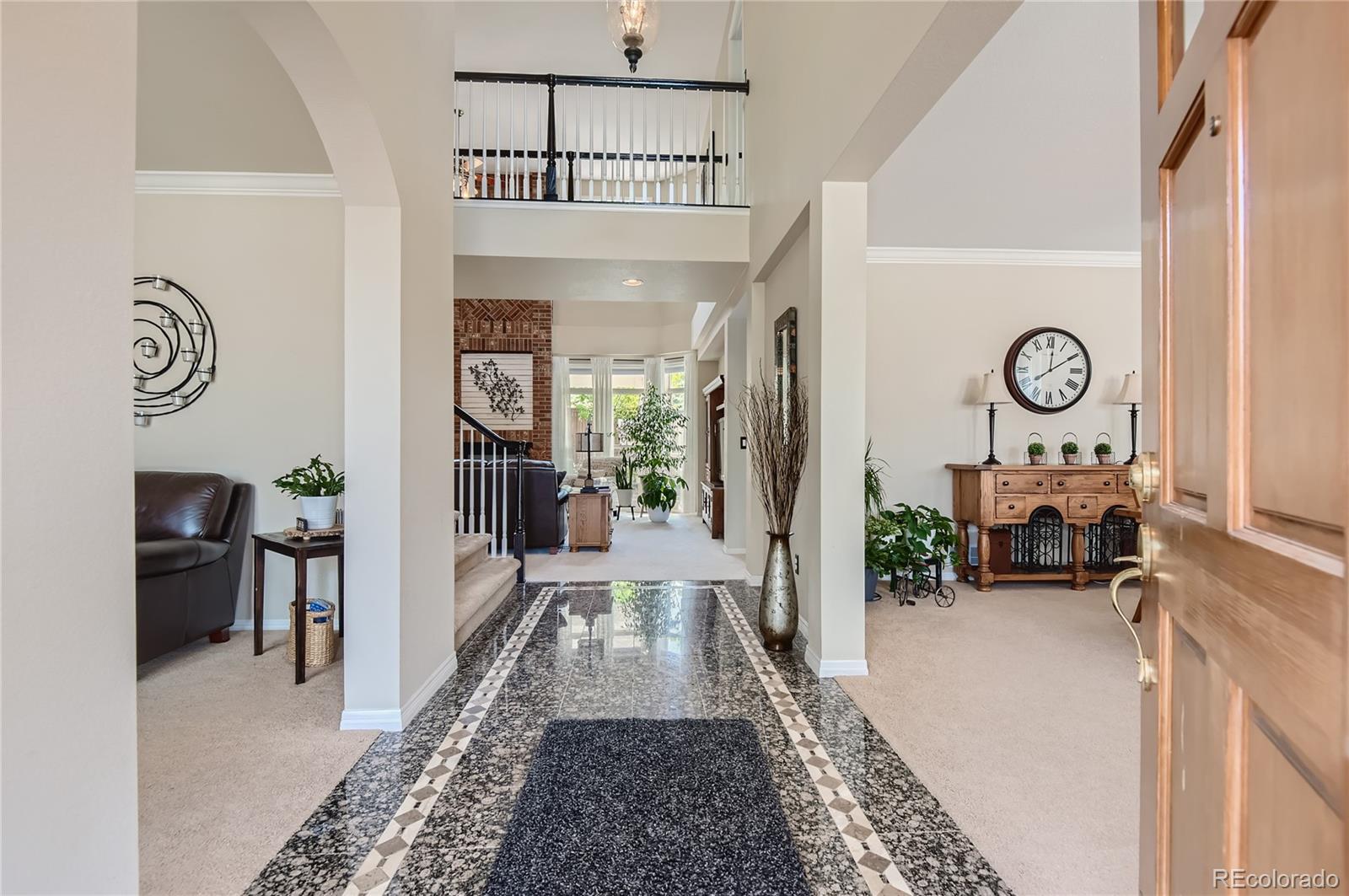 9212 Princeton Street Highlands Ranch, CO 80130 - Photo 4 of 40 a view of spacious hallway with furniture and floor to ceiling window