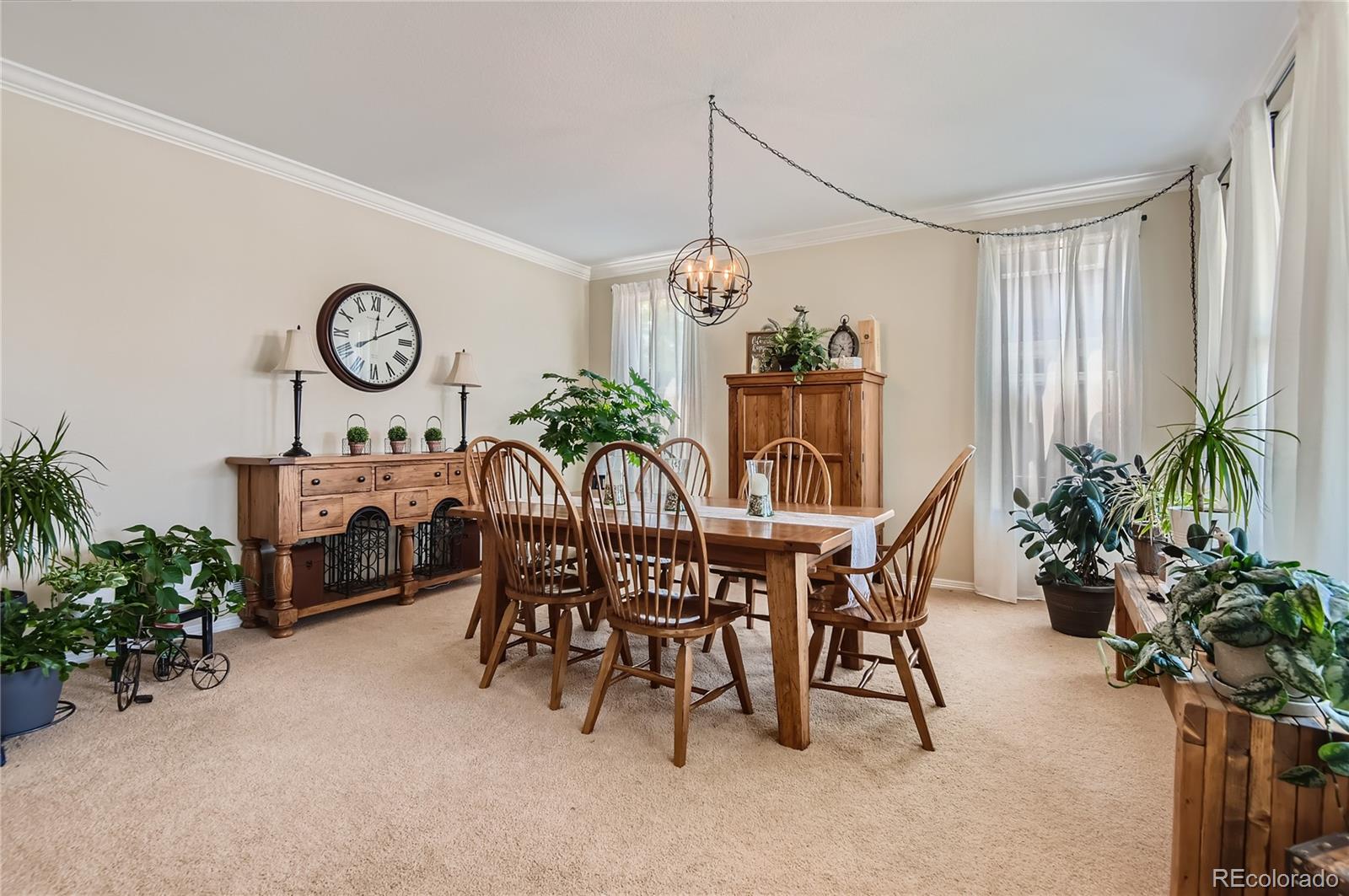 9212 Princeton Street Highlands Ranch, CO 80130 - Photo 5 of 40 a dining room with furniture potted plants and a table