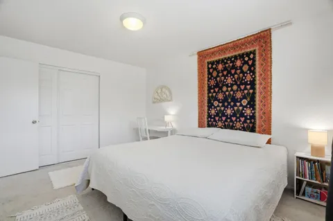 a bedroom with a bed and a book shelf