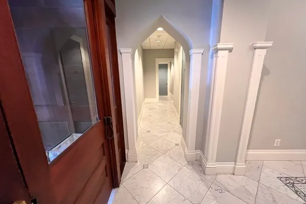 a view of a hallway with wooden floor and a shower