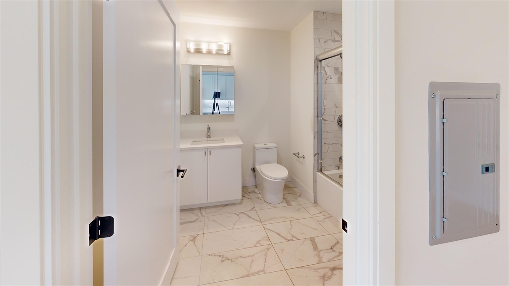 197 Green Street, Unit 402 Boston, MA 02130 - Photo 4 of 6 a bathroom with a toilet sink and a mirror