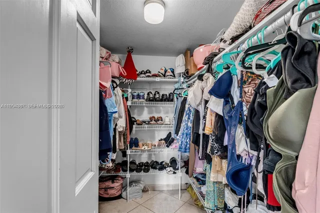 a view of walk in closet with clothes and shoes