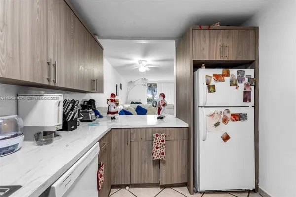 a view of kitchen with refrigerator and cabinets