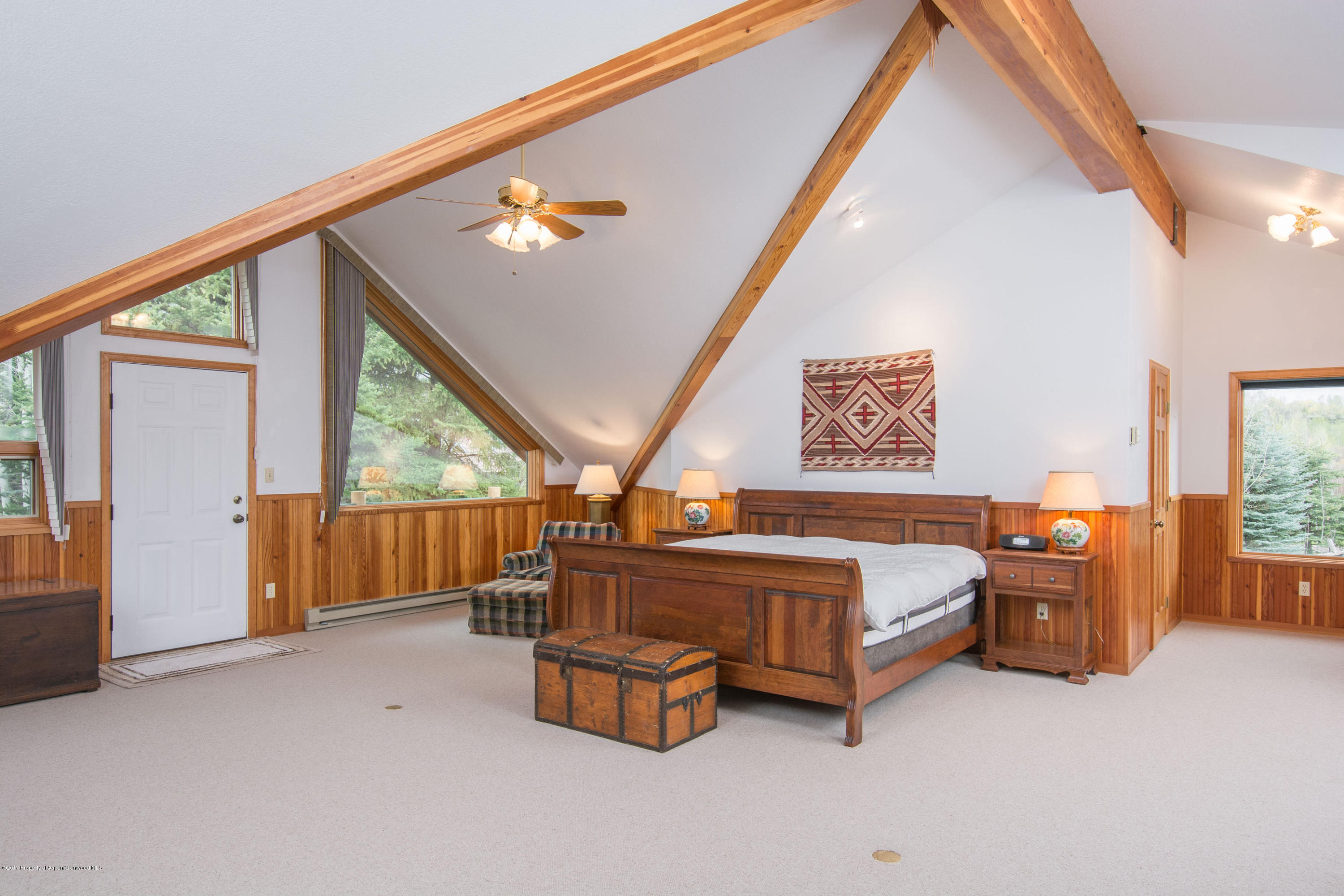 144 Haystack Lane Snowmass, CO 81654 - Photo 7 of 40 a spacious bedroom with a bed and large windows