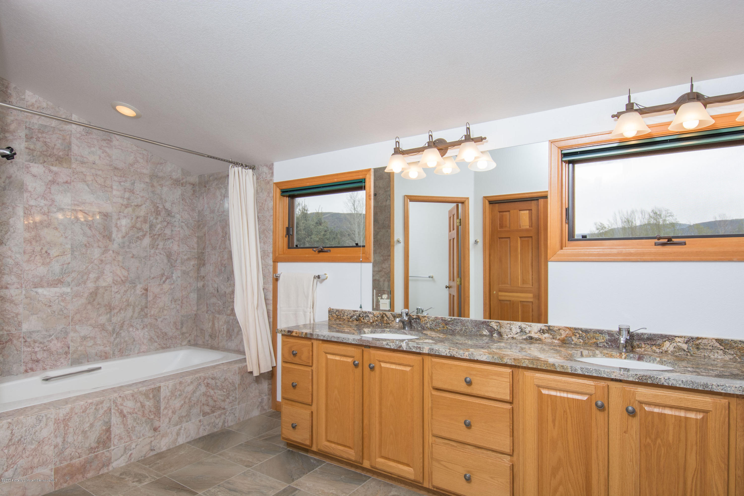 144 Haystack Lane Snowmass, CO 81654 - Photo 8 of 40 a bathroom with a granite countertop sink and a mirror